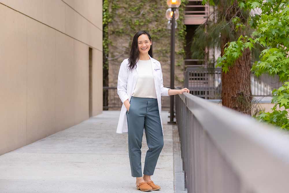 A portrait of Christine Hsieh, MD, standing outside in a white coat.
